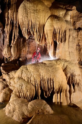 Grotte de l'Olivier (Lot) - Spéléo dans une alcôve au milieu de grandes coulées de calcite avec eau (SP-23-1808)